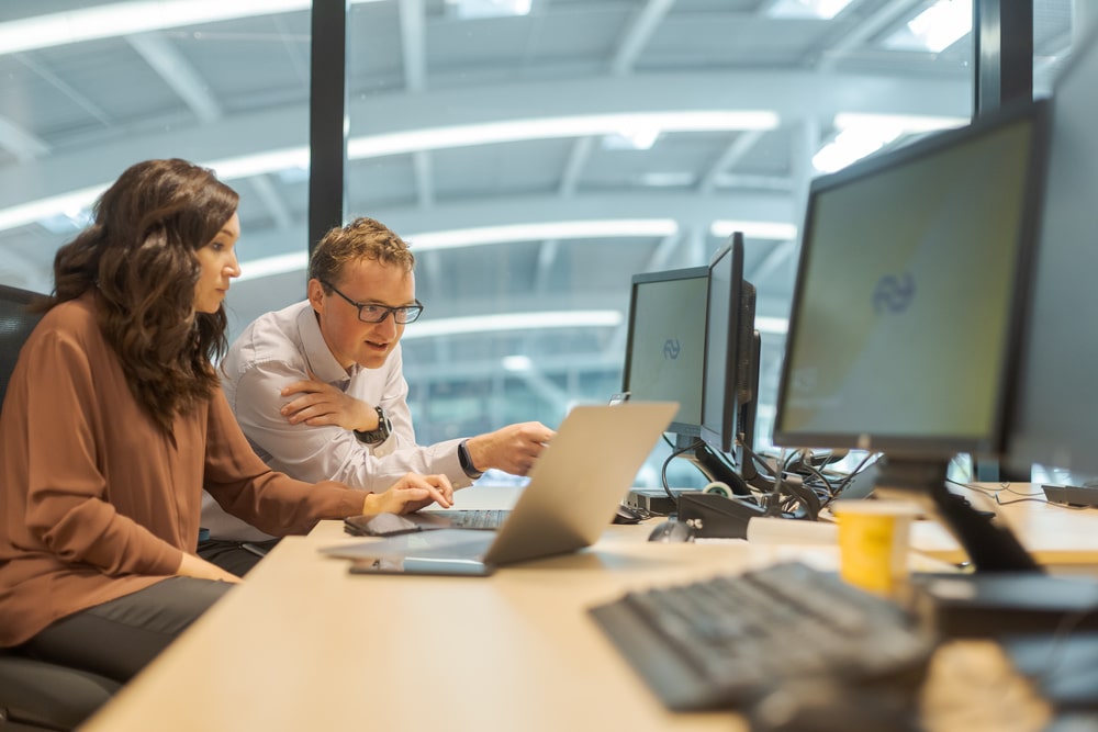 IT medewerkers werken samen achter laptop
