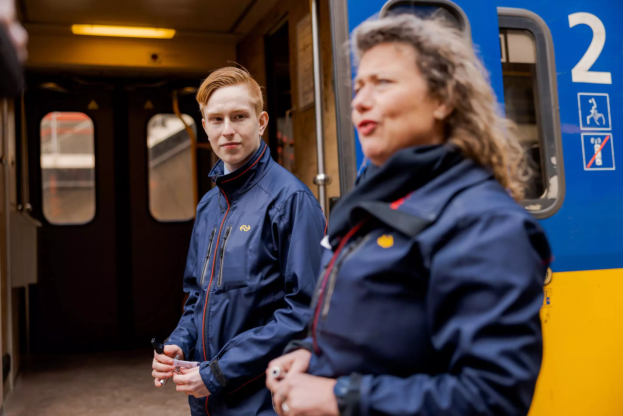 Conducteur en leerling staan voor een trein