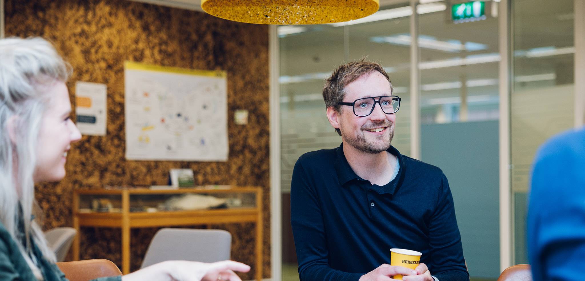NS collega in gesprek met andere collega's aan tafel