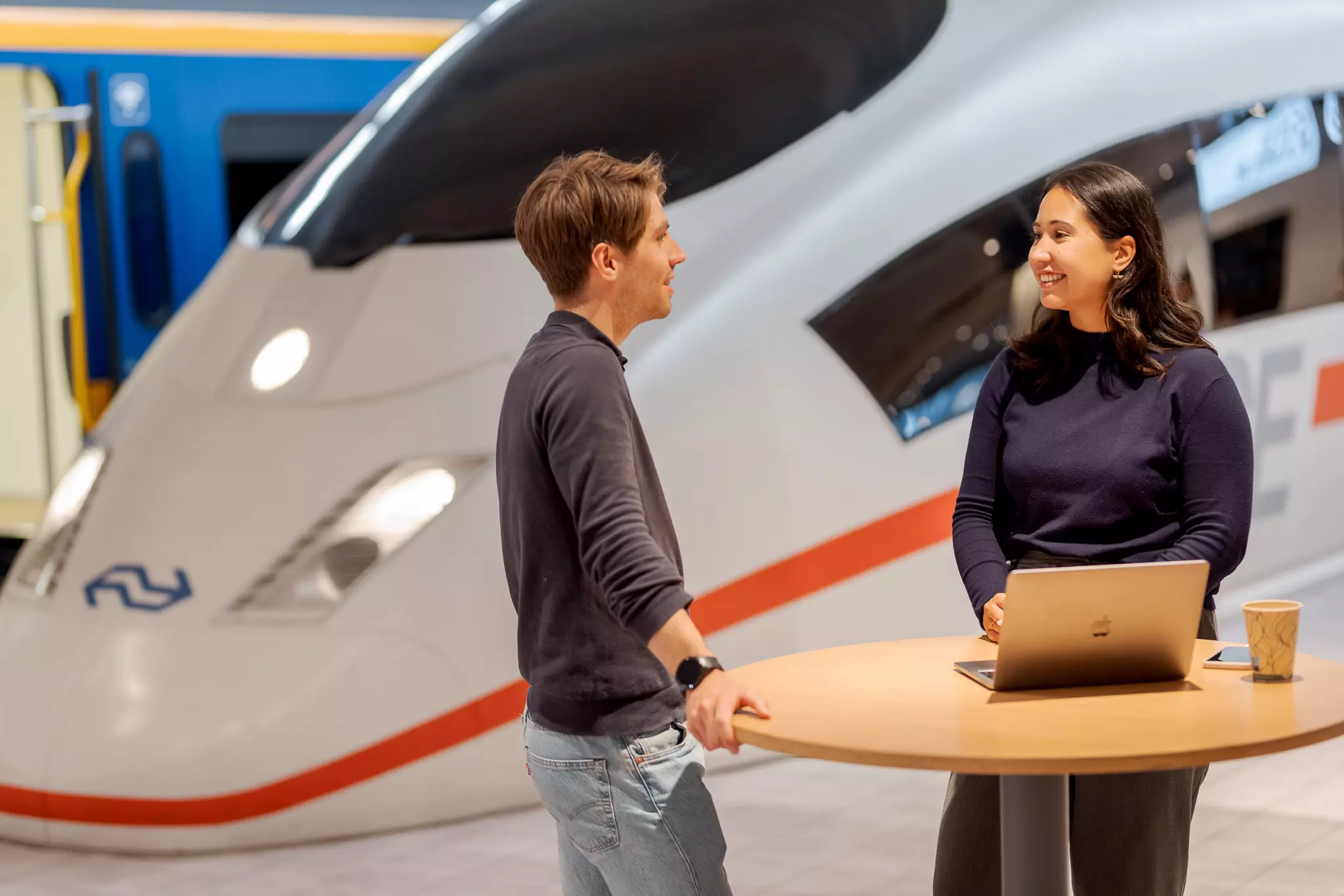 Evenementen bij NS Twee mensen kletsen voor een nep NS-trein in een evenementenzaal.